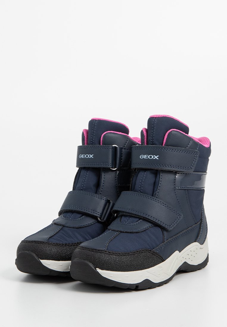 Kinder Winterstiefel in Marineblau mit pinkem Futter, zwei Klettverschlüssen, dicke Sohle in Weiß und Schwarz, mit der Marke "GEOX" auf den Riemen.