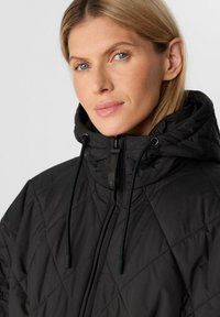 Schwarze gesteppte Winterjacke mit hohem Kragen, Reißverschluss und verstellbaren Kordeln. Glattes, strukturiertes Material mit Rautenmuster.