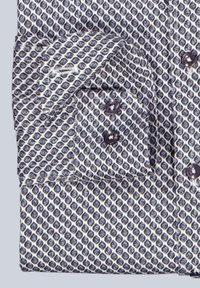 Gemustertes Hemd mit geometrischem Design in Marineblau und Weiß. Verfügt über einen Kragen, eine durch Knöpfe geschlossene Vorderseite und taillierte Manschetten. Glatte Stofftextur.