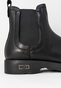 Stivale Chelsea nero con tomaia in pelle liscia, pannelli laterali elasticizzati, suola in gomma robusta e discreto logo metallizzato accentato sul tallone.