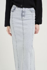 Denimskjørt i lyseblå, med en rett silhuett. Merkbare detaljer inkluderer vertikale sømmer og en lengde som når midt på leggen.