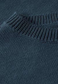 Dunkelblauer gestrickter Pullover im Close-up, der einen gerippten Ausschnitt und einen strukturierten Stoff mit gleichmäßigen Nähmustern zeigt.