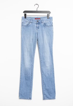 Vaqueros de mezclilla azul claro con corte recto, cinco bolsillos, un desgaste sutil y cierre con botón y cremallera. Se cuelga de una percha de plástico negro.