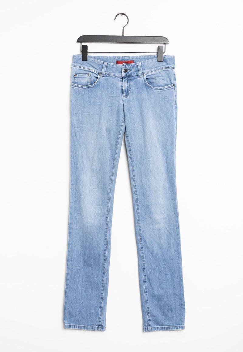 Vaqueros de mezclilla azul claro con corte recto, cinco bolsillos, un desgaste sutil y cierre con botón y cremallera. Se cuelga de una percha de plástico negro.