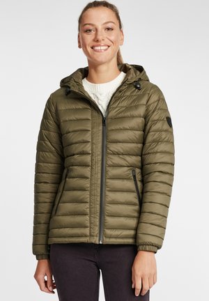 Oliven grøn pufferjakke med vandret quiltning, tilpasset hætte, frontlynlås og to sidelommer. Bæres over en krämstrikket sweater.