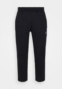 Svarta fleece-joggingbyxor med elastisk midja, sidofickor och en liten vit logotyp på låret, visade mot en enkel bakgrund.