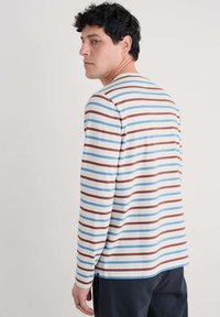 Camicia a maniche lunghe a righe color crema, con righe orizzontali blu e bordeaux. Tessuto in cotone morbido con una vestibilità rilassata.