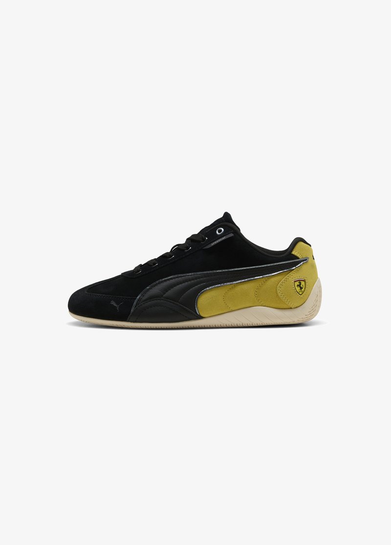 Baskets Puma basses noires et jaunes avec lacets noirs, semelle beige et logo Ferrari sur le côté du talon.
