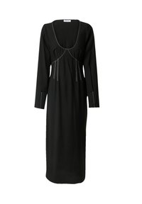 Schwarzes langärmliges Kleid mit quadratischem Ausschnitt, das auffällige weiße Nähte und eine fließende Silhouette aufweist, die bis zur Mitte der Waden reicht.