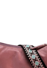 Roze leren handtas met een getextureerd oppervlak, met een zwarte band versierd met een geometrisch patroon in roze en turquoise. Ritssluiting aan de bovenkant.