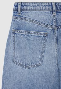 Ginn pantaloni jeans in denim azzurro chiaro vista posteriore che mostrano una tasca con toppa con cuciture visibili e texture, caratterizzati da un classico design a cinque tasche.
