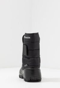 Mustat vedenpitävät talvijalkineet, joissa on tikattu kangaspäällinen, tarranauhakiinnitys ja kuvioitu kumipohja pitävyyttä varten. Columbia-logo näkyvissä varressa.