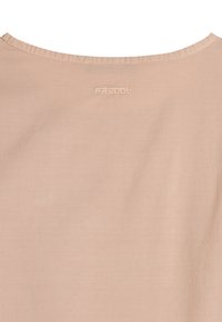 Camiseta de algodón beige con cuello redondo y logo bordado "FREDDY" en la parte superior de la espalda. Textura suave, diseño simple.