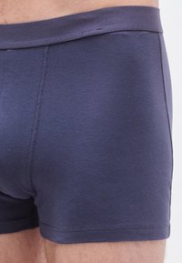 Boxer shorts de algodón azul oscuro con una cintura elástica y suave. Presentan una textura lisa y costuras cosidas para mayor durabilidad.