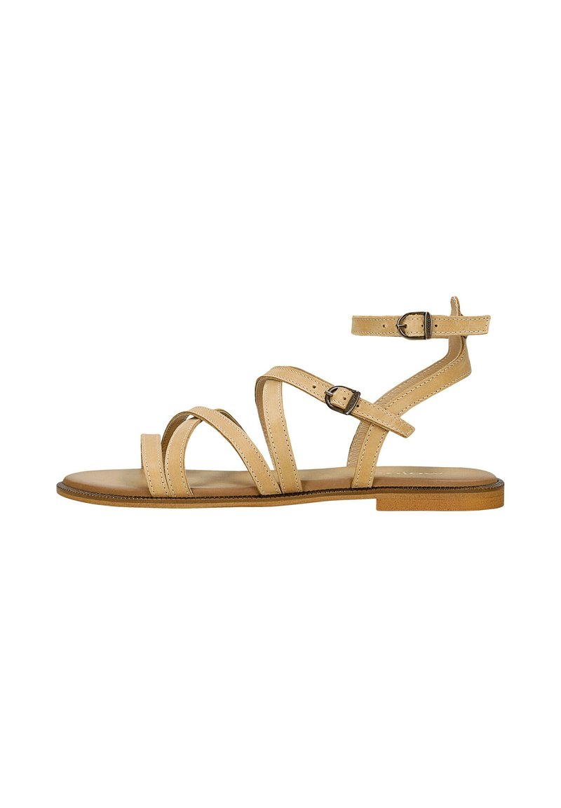 Sandali beige con cinturini sovrapposti, fibbia alla caviglia regolabile e suola piatta. Texture in pelle liscia e design minimalista.