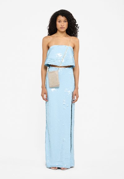Lichtblauw paillettenjurk, strapless bovenkant met gelaagd ontwerp, lange nauwsluitende rok met zijspleet, gecombineerd met een kleine metalen crossbody tas.