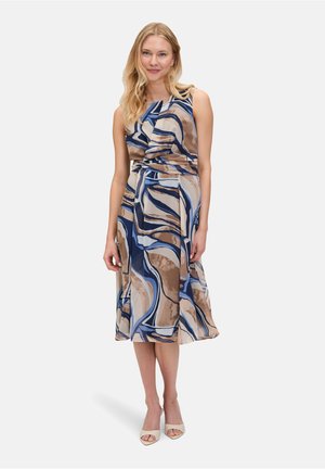 Mouwloze wikkeljurk in beige met een abstract patroon in blauw en bruin, uitstraling met een gedefinieerde taille en een vloeiende rok. Gladde stoftextuur.