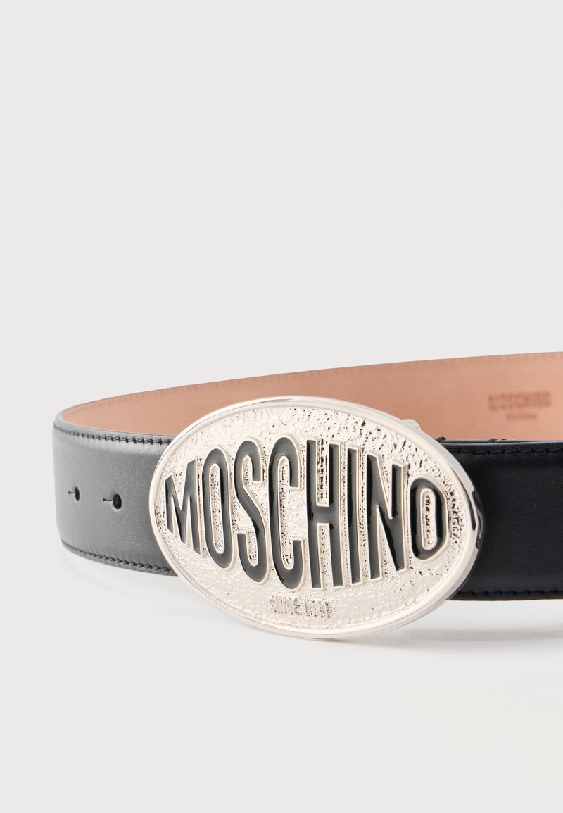 Zwarte leren riem met grote ovale zilveren gesp met verhoogde "MOSCHINO" letters.
