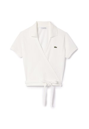 White short-sleeve wrap polo shirt with a collar, featuring a tie at the waist and a small green Lacoste logo. Smooth cotton texture.