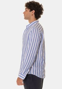 Camicia a maniche lunghe a righe azzurro chiaro e bianco, realizzata in tessuto testurizzato, con colletto button-down e polsini a contrasto.