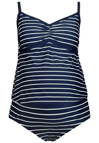 Tummansininen tankini, jossa on valkoisia vaakasuoria raitoja, varustettuna säädettävillä olkaimilla, rypytetyllä edustalla ja levenevällä helman, joka tarjoaa lisäsuojaa.