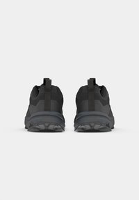 Zapatos deportivos negros con parte superior de tela texturizada, suela de goma resistente y lengüetas en el talón para facilitar el uso. Diseñados para la durabilidad.