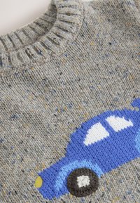 Grå stickad tröja med blå bilmotiv. Har ribbad krage, mjuk textur och melerat garn med gula och blå accenter.