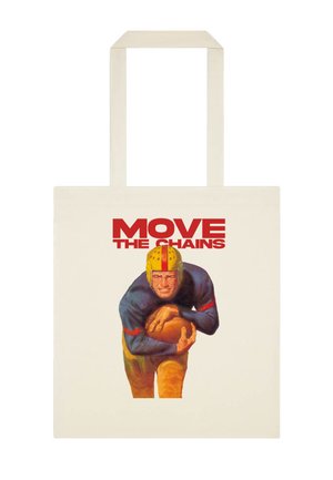 Joueur de football en uniforme vintage tenant un ballon, avec un texte rouge audacieux "MOVE THE CHAINS" au-dessus sur un sac fourre-tout beige.