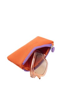 Pomarańczowe etui na okulary z neoprenu z fioletowym zamkiem błyskawicznym i akcentami, zawierające przezroczyste okulary przeciwsłoneczne z jasnoróżową oprawką i subtelnymi detalami.