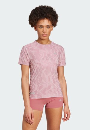Camiseta atlética de manga corta en rosa claro con un patrón de zigzag texturizado. Fabricada con material transpirable, presenta un cuello redondo y un corte ajustado.