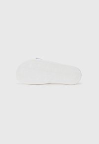 White sneaker sole with a hexagonal pattern and textured grip. Rounded shape with slight upward curve at the toe. Minimal design with no visible accents.
