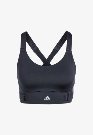 Sujetador deportivo negro con tirantes cruzados en la espalda, textura de tela suave, banda ajustable y un pequeño logo blanco en la parte inferior.