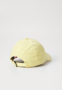 Gul bomulls baseballcaps med buet skygge, justerbar stropp bak og sydd detaljer på kronen.