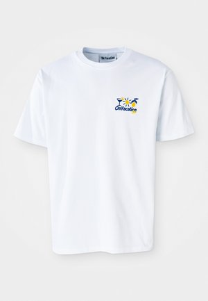 White cotton t-shirt featuring a small, colorful graphic with the text "On Vacation" and illustrations of drinks and flowers.