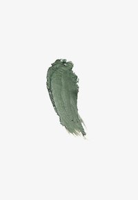 Metallisk grön kosmetisk ögonskugga som strykit ut med texturerade kanter på vit bakgrund.