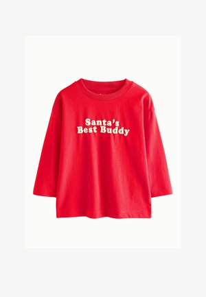 Rød langærmet skjorte med hvid tekst, der lyder "Santa's Best Buddy", på forsiden mod en ensartet hvid baggrund.