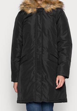 Parka imbottita nera con cappuccio foderato in pelliccia sintetica, dotata di tasche laterali e silhouette dritta, realizzata in tessuto liscio e lucido.