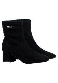 Botines de ante negro hasta el tobillo con puntera afilada y tacón cuadrado, que cuentan con un acento de logo plateado en el lateral. Textura suave en toda su superficie.