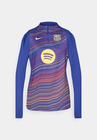 Dugački plavi džemper s polu-zipom, s gradijentnim valovitim uzorkom u crvenoj, žutoj i ljubičastoj boji. Uključuje žuti Spotify logo.
