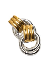 Splecione srebrne i złote metalowe pierścienie o gładkich, błyszczących powierzchniach tworzące dekoracyjny węzeł na białym tle.