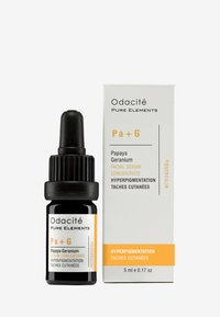 Svart glassdråpeflaske med ribbet hette, med hvit og gul tekst. Accompanert av en hvit boks merket "Odacité Pure Elements."