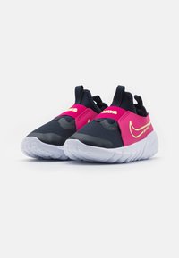 Buty sportowe w różowo-czarnym wzorze, wykonane z oddychającego materiału, w stylu zakładanym, z białą gumową podeszwą i żółtym logo.