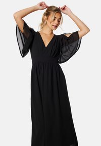 Schwarzes Maxikleid mit durchsichtigen, schwingenden Ärmeln, V-Ausschnitt und geraffter Taille. Glattes Gewebe mit fließender Silhouette.