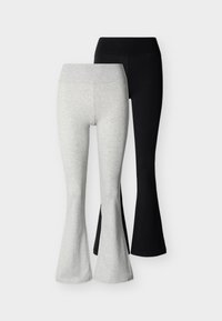 Δύο ζευγάρια φαρδιές κολάν, ένα ανοιχτό γκρι και ένα μαύρο, απεικονίζονται σε απλό λευκό φόντο.