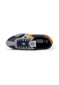 Scarpa sportiva blu e grigia realizzata in materiali scamosciati e nylon. Presenta dettagli arancioni, lacci a trama e una suola in gomma testurizzata.