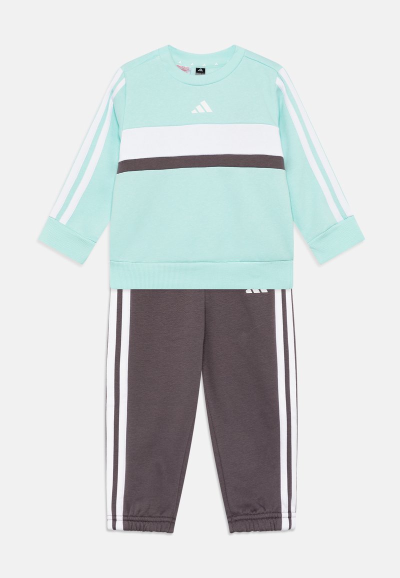 Sudadera verde menta con rayas horizontales blancas y gris oscuro, combinada con pantalones de chándal grises que tienen rayas laterales blancas. Tejido de mezcla de algodón.
