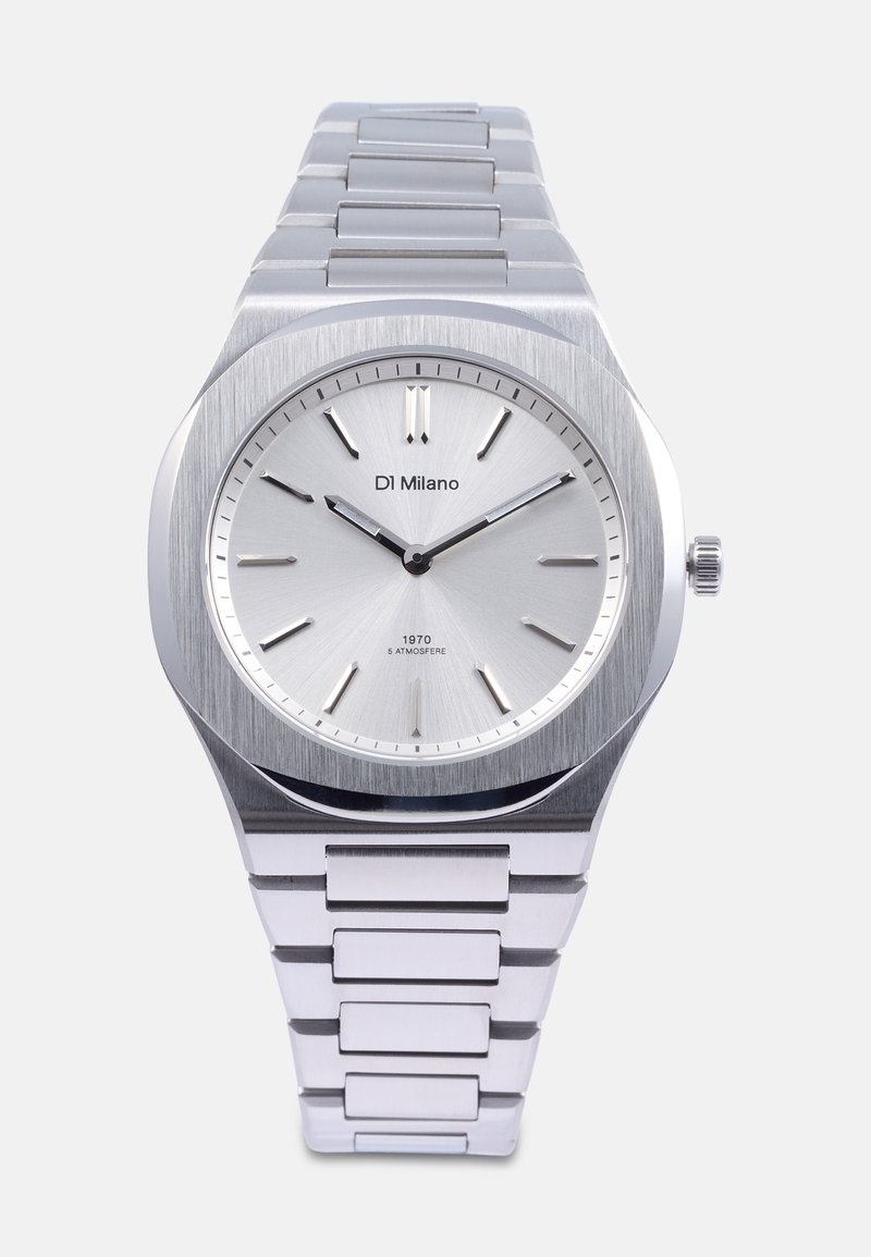 Reloj de acero inoxidable plateado con acabado cepillado, cara minimalista, marcadores de hora y pulsera de eslabones. Cuenta con una caja redonda y una corona.