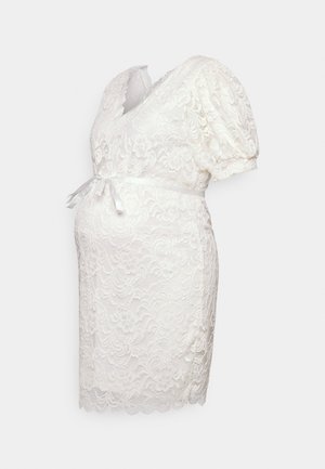 Hvid blonde graviditetkjole med omslagsdesign, korte pufærmer og satinbælte. Scalloperet nederkant og blomsterprint overalt.