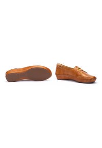 Zapatos de cuero color marrón claro con un perfil bajo, detalles de costura y una suela de goma texturizada. Presentan un diseño con cordones y punta redondeada.