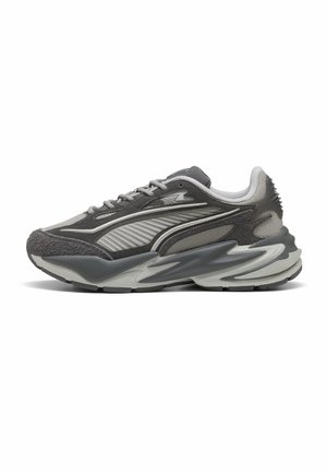 Baskets de sport grises et argent avec panneaux texturés superposés, semelle épaisse sculptée et design à lacets, vues de côté sur fond blanc.